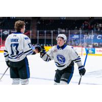 Wenatchee Wild forward Riley Bassen exchanges glove-taps with Blake Vanek (17, left)